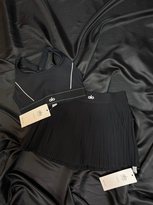 Alo Yoga – Conjunto Bra & Falda Plisada Negra con Detalles en Blanco